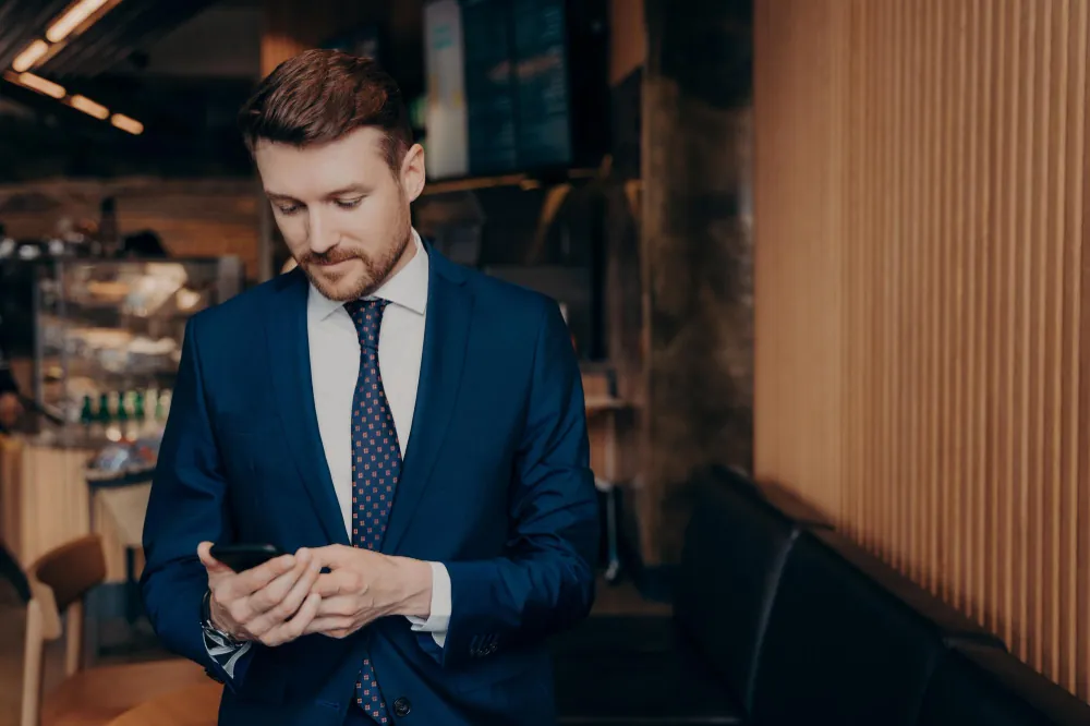 Successful mature man reading a first message on his phone