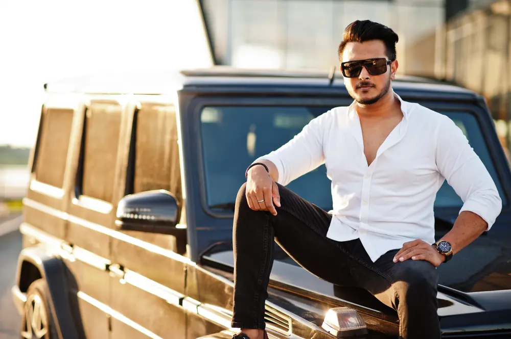 An Indian man standing beside a vehicle outdoors
